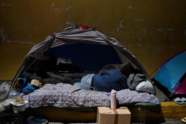 A man waits for news of prisoners in his tent set up outside Zone 7 of the Bolivarian National Police (PNB), also known as the Boleita Detention and Custody Center, in Sucre municipality, Caracas, on January 22, 2026. Exiled opposition figurehead Edmundo Gonzalez Urrutia on January 22 demanded "freedom for all people unfairly detained" in Venezuela, after the authorities released his son-in-law following a year in prison on terrorism charges. (Photo by Juan BARRETO / AFP)