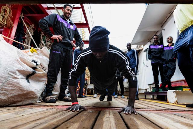 (FILES) A migrant does push-ups onboard the rescue ship "Ocean Viking" operated by the NGO SOS Mediterranee, as it sails in the Mediterranean Sea toward the designated port of disembarkation in Palermo, southern Italy, on January 18, 2026. (Photo by Sameer Al-DOUMY / AFP)