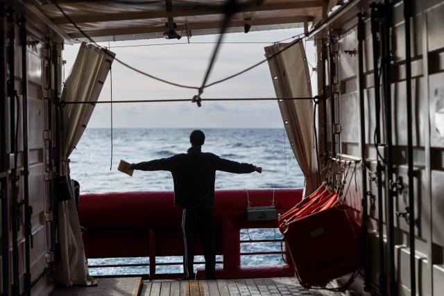 (FILES) A migrant stretches his body onboard of the rescue ship "Ocean Viking" operated by the NGO SOS Mediterranee, as they sail at sea to the designated port of disembarkation in Savona, northwestern Italy, on January 3, 2026. (Photo by Sameer Al-DOUMY / AFP)