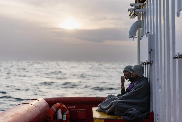 (FILES) Bangladeshi migrants sit on the aft deck of the rescue ship "Ocean Viking" operated by the NGO SOS Mediterranee, as it sails in the Mediterranean Sea toward the designated port of disembarkation in Palermo, southern Italy, on January 18, 2026. (Photo by Sameer Al-DOUMY / AFP)