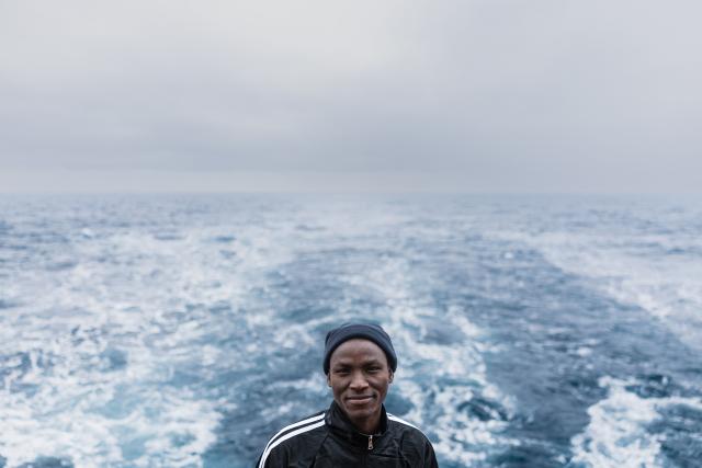 (FILES) A migrant poses for a photograph onboard of the rescue ship "Ocean Viking" operated by the NGO SOS Mediterranee, as they sail at sea to the designated port of disembarkation in Savona, northwestern Italy, on January 4, 2026. (Photo by Sameer Al-DOUMY / AFP)