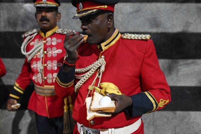 A member of Tamil Nadu police band eats his snack during a rehearsal for the upcoming Republic Day celebrations in Chennai on January 23, 2026. (Photo by R.Satish BABU / AFP)