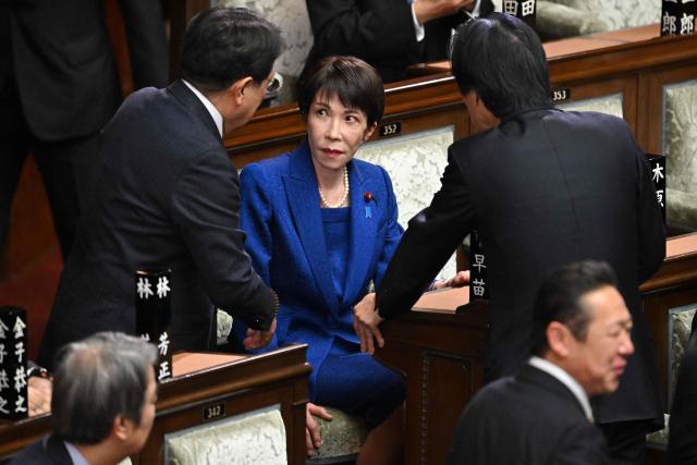 Japan's Prime Minister Sanae Takaichi (C) chats with diet members before a plenary session of the House of Representatives at the Diet in Tokyo on January 23, 2026. Takaichi dissolved parliament ahead of a snap election on February 8, counting on her cabinet's high poll numbers to steer her otherwise unpopular ruling party to victory. (Photo by Kazuhiro NOGI / AFP)
