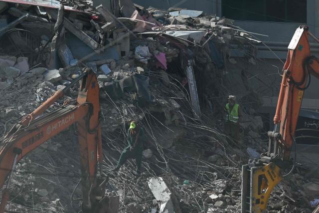 Rescue workers clear debris at the shopping mall in Karachi on January 23, 2026 following a massive fire that broke out on January 17. The death toll from a mall fire in Pakistan's biggest city rose to at least 67 people, an unnamed spokesperson from the local government said on January 23. (Photo by Rizwan TABASSUM / AFP)