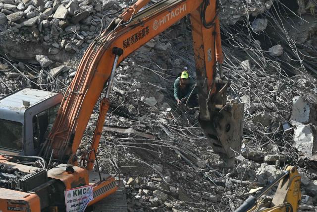 Rescue workers clear debris at the shopping mall in Karachi on January 23, 2026 following a massive fire that broke out on January 17. The death toll from a mall fire in Pakistan's biggest city rose to at least 67 people, an unnamed spokesperson from the local government said on January 23. (Photo by Rizwan TABASSUM / AFP)