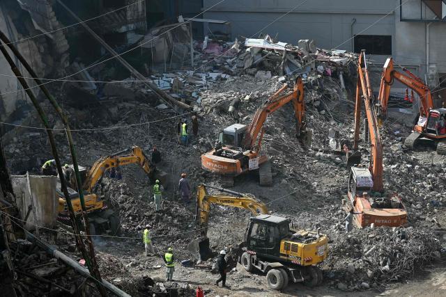 Rescue workers clear debris at the shopping mall in Karachi on January 23, 2026 following a massive fire that broke out on January 17. The death toll from a mall fire in Pakistan's biggest city rose to at least 67 people, an unnamed spokesperson from the local government said on January 23. (Photo by Rizwan TABASSUM / AFP)