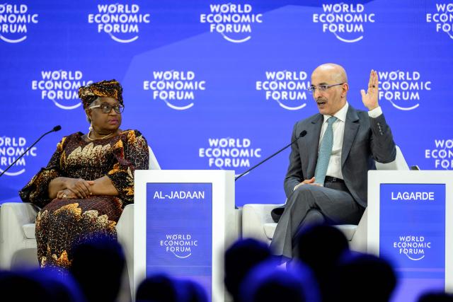 Saudi Arabia's Finance Minister Mohammed Al-Jadaan (R) gestures next to World Trade Organization (WTO) Director-General Ngozi Okonjo-Iweala during a session during the final day of the World Economic Forum (WEF) annual meeting in Davos on January 23, 2026. (Photo by Fabrice COFFRINI / AFP)