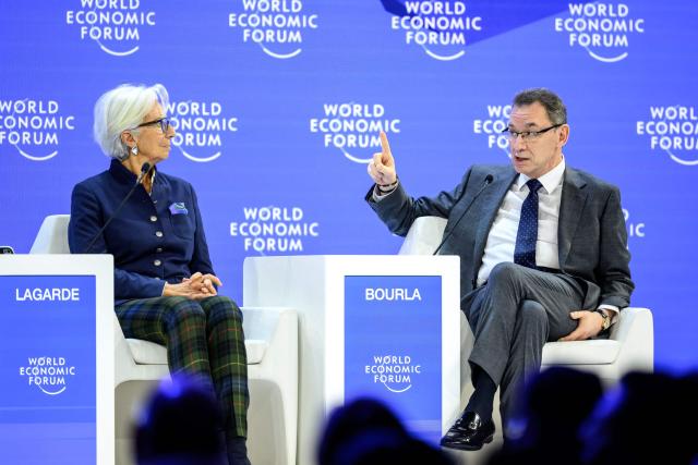Pfizer Chairman and CEO Albert Bourla (R) gestures next to European Central Bank (ECB) president Christine Lagarde during a session during the final day of the World Economic Forum (WEF) annual meeting in Davos on January 23, 2026. (Photo by Fabrice COFFRINI / AFP)