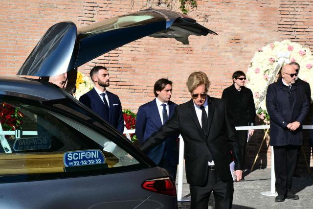 Vernon Bruce Hoeksema touches the coffin of the late Italian fashion designer Valentino Gavarani after the funeral ceremony at the Basilic of Santa Maria degli Angeli e dei Martiri in Rome on January 23, 2026. (Photo by Stefano RELLANDINI / AFP)