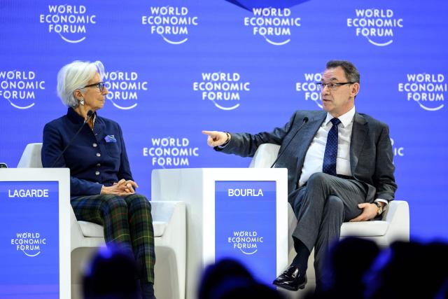 Pfizer Chairman and CEO Albert Bourla (R) gestures next to European Central Bank (ECB) president Christine Lagarde during a session during the final day of the World Economic Forum (WEF) annual meeting in Davos on January 23, 2026. (Photo by Fabrice COFFRINI / AFP)