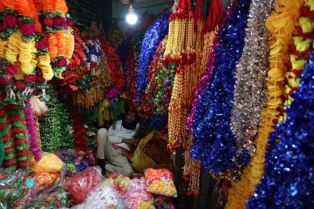 A vendor selling decorative garlands, waits for customers in Varanasi on January 23, 2026. (Photo by Niharika KULKARNI / AFP)