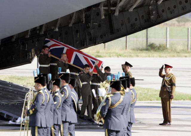 (FILES) The coffin containing Joseph David Windall of the British Royal Marines is carried from a C17 plane at RAF Kinloss, in Scotland, 12 September 2006. Windall was one of 14 British servicemen killed when the Nimrod aircraft they were travelling in crashed in Afghanistan earlier this month. Britain said Donald Trump was "wrong to diminish" the role of NATO troops in Afghanistan, as a claim by the US president that they did not fight on the front line sparked outrage. In an interview with Fox News aired on Thursday, January 22, 2026, Trump appeared unaware that 457 British soldiers died during the conflict in the South Asian country following the September 11 attacks on the United States. (Photo by ANDREW MILLIGAN / POOL / AFP)