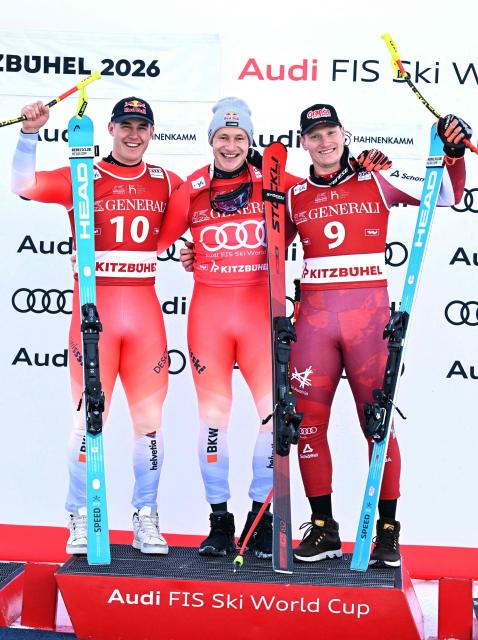 (L-R) Second placed Switzerland's Franjo Von Allmen, winner Switzerland's Marco Odermatt and third placed Austria's Stefan Babinsky celebrate on the podium after the Men's Super-G event of the FIS Alpine Skiing World Cup in Kitzbuehel, Austria, on January 23, 2026 (Photo by BARBARA GINDL / APA / AFP) / Austria OUT