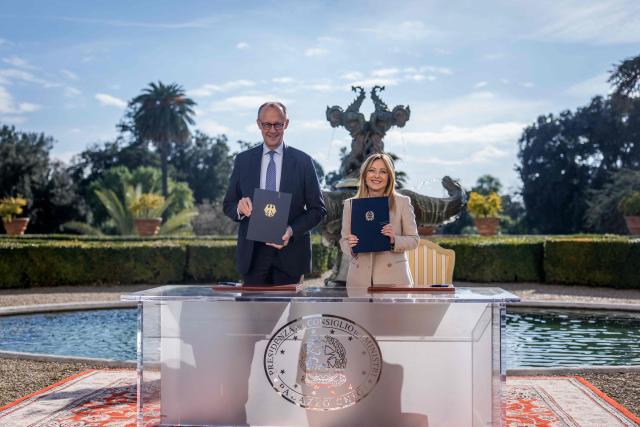 German Chancellor Friedrich Merz (L) and Italy's Prime Minister Giorgia Meloni pose with documents during a signing ceremony of bilateral agreements on strategic cooperation at an Intergovernmental Summit between Italy and Germany in Rome, Italy, on January 23, 2026. (Photo by Michael Kappeler / POOL / AFP)