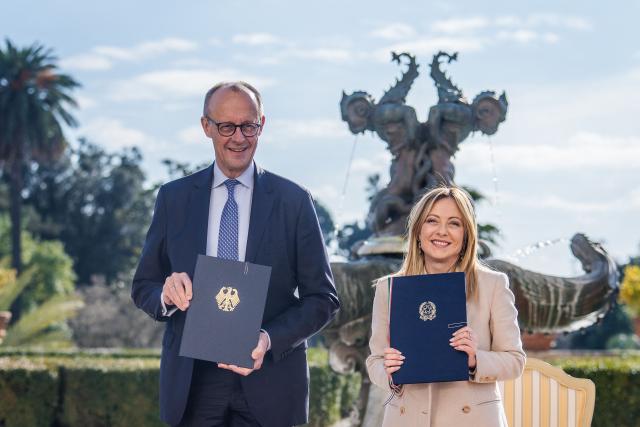 German Chancellor Friedrich Merz (L) and Italy's Prime Minister Giorgia Meloni pose with documents during a signing ceremony of bilateral agreements on strategic cooperation at an Intergovernmental Summit between Italy and Germany in Rome, Italy, on January 23, 2026. (Photo by Michael Kappeler / POOL / AFP)