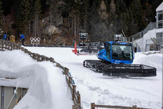 Staff members work on the snow prepping at the Biathlon venue in Antholz, northern Italy prior to the Milano Cortina 2026 Olympic Games, on January 23, 2026. (Photo by Odd ANDERSEN / AFP)