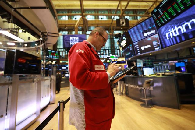 A trader works on the floor of the New York Stock Exchange (NYSE) at the opening bell in New York on January 23, 2026. Stocks were subdued and precious metals hit fresh highs Friday after a turbulent week that saw US President Donald Trump back down from threats to seize Greenland and to issue tariffs against European allies. (Photo by TIMOTHY A. CLARY / AFP)