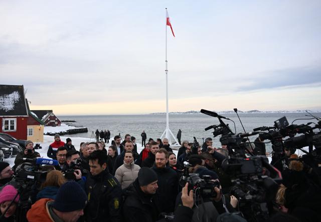 Journalists surround Greenland's Prime Minister Jens-Frederik Nielsen (C L) and Danish Prime Minister Mette Frederiksen (C R), in Nuuk, Greenland, on January 23, 2026. Frederiksen will hold talks with her Greenlandic counterpart after a turbulent week that saw US President Donald Trump back down from his threats to seize the Arctic island and agree to talks. Frederiksen travelled to the Greenland capital Nuuk from Brussels, where she held talks earlier with NATO Secretary General Mark Rutte, who reached a purported deal with Trump on Greenland at the World Economic Forum in Davos. (Photo by Jonathan Nackstrand / AFP)