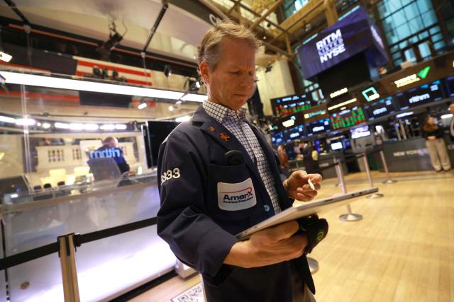 A trader works on the floor of the New York Stock Exchange (NYSE) at the opening bell in New York on January 23, 2026. Stocks were subdued and precious metals hit fresh highs Friday after a turbulent week that saw US President Donald Trump back down from threats to seize Greenland and to issue tariffs against European allies. (Photo by TIMOTHY A. CLARY / AFP)