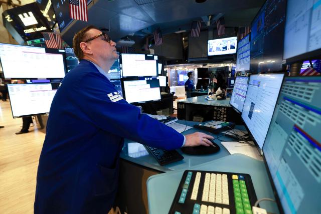 A trader works on the floor of the New York Stock Exchange (NYSE) at the opening bell in New York on January 23, 2026. Stocks were subdued and precious metals hit fresh highs Friday after a turbulent week that saw US President Donald Trump back down from threats to seize Greenland and to issue tariffs against European allies. (Photo by TIMOTHY A. CLARY / AFP)