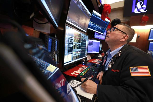 A trader works on the floor of the New York Stock Exchange (NYSE) at the opening bell in New York on January 23, 2026. Stocks were subdued and precious metals hit fresh highs Friday after a turbulent week that saw US President Donald Trump back down from threats to seize Greenland and to issue tariffs against European allies. (Photo by TIMOTHY A. CLARY / AFP)