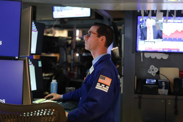 A trader works on the floor of the New York Stock Exchange (NYSE) at the opening bell in New York on January 23, 2026. Stocks were subdued and precious metals hit fresh highs Friday after a turbulent week that saw US President Donald Trump back down from threats to seize Greenland and to issue tariffs against European allies. (Photo by TIMOTHY A. CLARY / AFP)