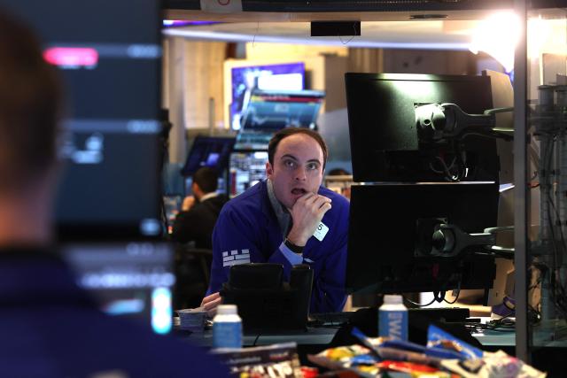 Traders work on the floor of the New York Stock Exchange (NYSE) at the opening bell in New York on January 23, 2026. Stocks were subdued and precious metals hit fresh highs Friday after a turbulent week that saw US President Donald Trump back down from threats to seize Greenland and to issue tariffs against European allies. (Photo by TIMOTHY A. CLARY / AFP)