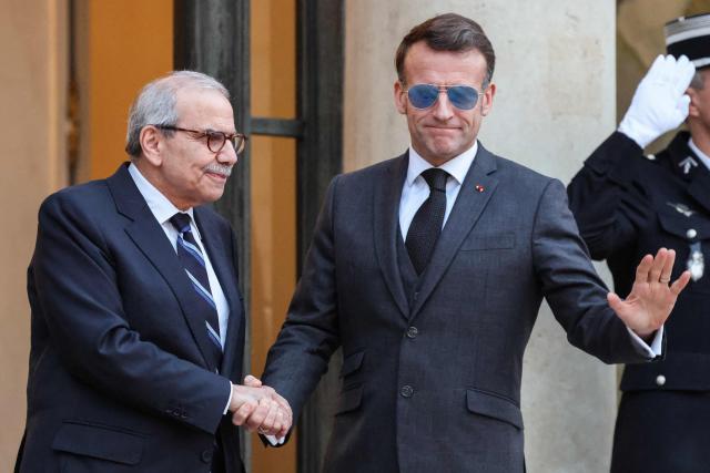 France's President Emmanuel Macron (R) wearing sunglasses shakes hands with Lebanon's Prime Minister Nawaf Salam prior to their meeting at the Elysee presidential palace in Paris, on January 23, 2026. (Photo by Ludovic MARIN / AFP)