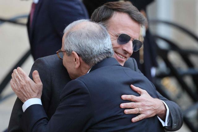 France's President Emmanuel Macron (Top) wearing sunglasses embraces with Lebanon's Prime Minister Nawaf Salam prior to their meeting at the Elysee presidential palace in Paris, on January 23, 2026. (Photo by Ludovic MARIN / AFP)