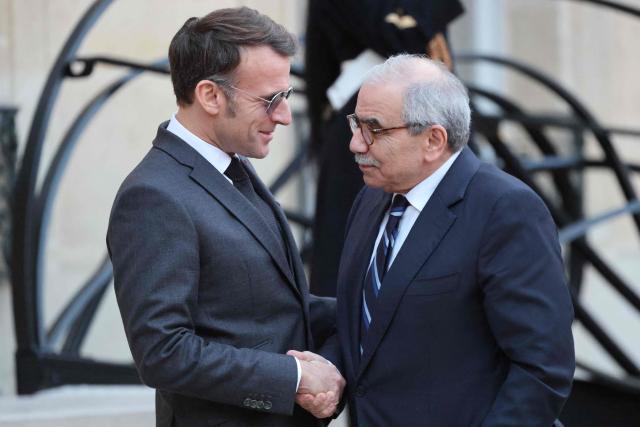 France's President Emmanuel Macron (L) wearing sunglasses shakes hands with Lebanon's Prime Minister Nawaf Salam prior to their meeting at the Elysee presidential palace in Paris, on January 23, 2026. (Photo by Ludovic MARIN / AFP)
