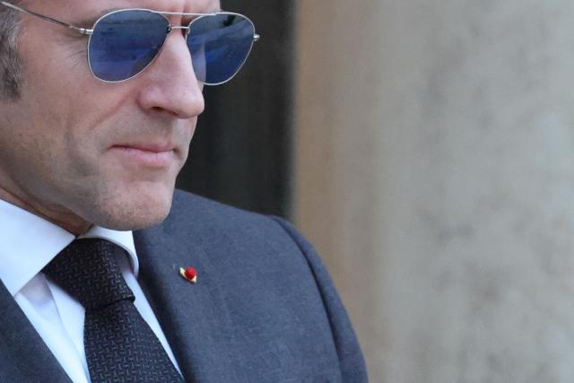 France's President Emmanuel Macron wearing sunglasses reacts as he waits for Lebanon's Prime Minister's arrival prior to their meeting at the Elysee presidential palace in Paris, on January 23, 2026. (Photo by Ludovic MARIN / AFP)