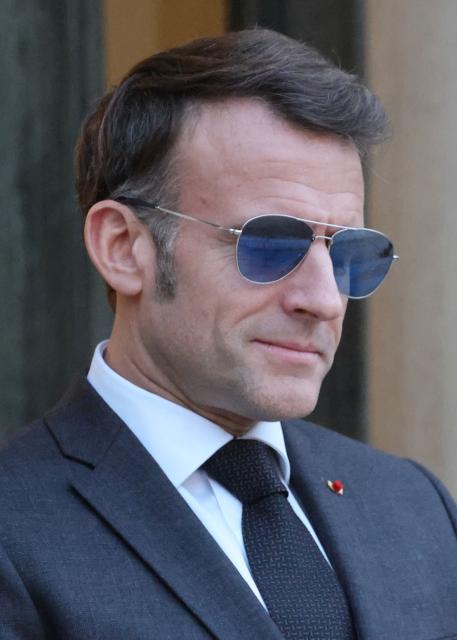 France's President Emmanuel Macron wearing sunglasses reacts as he waits for Lebanon's Prime Minister's arrival prior to their meeting at the Elysee presidential palace in Paris, on January 23, 2026. (Photo by Ludovic MARIN / AFP)