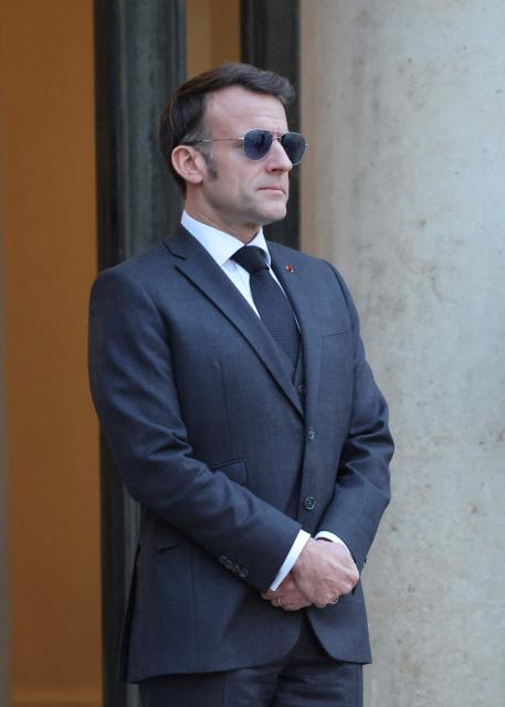 France's President Emmanuel Macron wearing sunglasses reacts as he waits for Lebanon's Prime Minister's arrival prior to their meeting at the Elysee presidential palace in Paris, on January 23, 2026. (Photo by Ludovic MARIN / AFP)