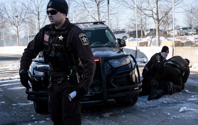 An activist is arrested by officers of the Hennepin County Sheriffs Office after some protesters attempted to block the street in front of the Bishop Henry Whipple Federal Building during the "ICE out of Minnesota: Day of Truth and Freedom" protest in Minneapolis, Minnesota on January 23, 2026. The Pentagon has ordered 1,500 US soldiers to prepare for a possible deployment to a state roiled by unrest over an immigration crackdown, US media reported on January 18. The reported preparations come days after President Donald Trump threatened to invoke the Insurrection Act, which enables use of the military to suppress "armed rebellion" or "domestic violence" -- although a day later he said there was no immediate need for it. (Photo by ROBERTO SCHMIDT / AFP)