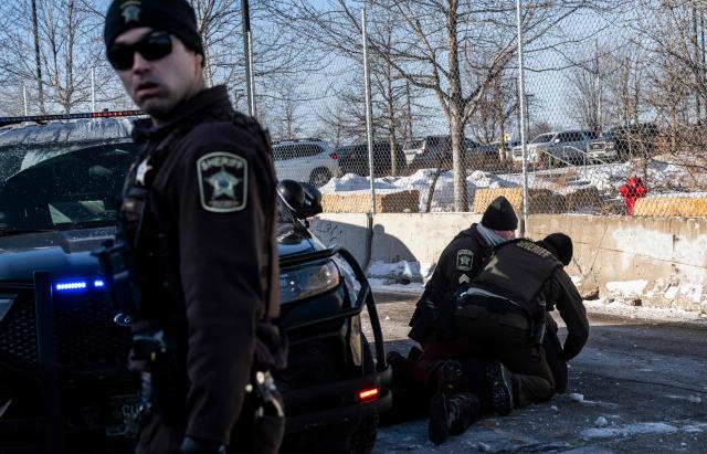 An activist is arrested by officers of the Hennepin County Sheriffs Office after some protesters attempted to block the street in front of the Bishop Henry Whipple Federal Building during the "ICE out of Minnesota: Day of Truth and Freedom" protest in Minneapolis, Minnesota, on January 23, 2026. The Pentagon has ordered 1,500 US soldiers to prepare for a possible deployment to a state roiled by unrest over an immigration crackdown, US media reported on January 18. The reported preparations come days after President Donald Trump threatened to invoke the Insurrection Act, which enables use of the military to suppress "armed rebellion" or "domestic violence" -- although a day later he said there was no immediate need for it. (Photo by ROBERTO SCHMIDT / AFP)