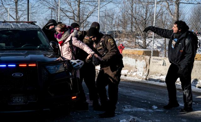 An activist is arrested by officers of the Hennepin County Sheriffs Office after some protesters attempted to block the street in front of the Bishop Henry Whipple Federal Building during the "ICE out of Minnesota: Day of Truth and Freedom" protest in Minneapolis, Minnesota on January 23, 2026. The Pentagon has ordered 1,500 US soldiers to prepare for a possible deployment to a state roiled by unrest over an immigration crackdown, US media reported on January 18. The reported preparations come days after President Donald Trump threatened to invoke the Insurrection Act, which enables use of the military to suppress "armed rebellion" or "domestic violence" -- although a day later he said there was no immediate need for it. (Photo by ROBERTO SCHMIDT / AFP)