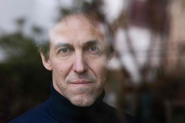 French researcher Laurent Vinatier, who was arrested in Russia in June 2024 and released in January 2026, poses behind a window in his family house in Issy-les-Moulineaux on January 23, 2026. French researcher Laurent Vinatier arrived in France on January 8, 2026 following a prisoner exchange involving a Russian basketball player wanted in the United States. (Photo by JOEL SAGET / AFP)