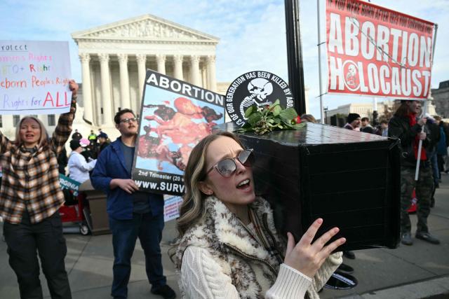 A person carries a makeshift baby coffin in front of the US Supreme Court building during the 53rd annual March for Life rally on the National Mall in Washington, DC, on January 23, 2026. The annual pro-life demonstration, themed "Life is a Gift," marks the anniversary of the Roe v. Wade decision and includes a march toward Capitol Hill. (Photo by SAUL LOEB / AFP)