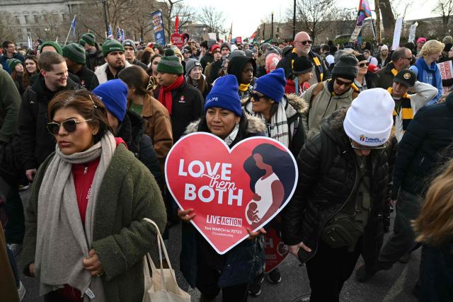 People hold signs as they march in the 53rd annual March for Life rally in Washington, DC, on January 23, 2026. The annual pro-life demonstration, themed "Life is a Gift," marks the anniversary of the Roe v. Wade decision and includes a march toward Capitol Hill. (Photo by SAUL LOEB / AFP)