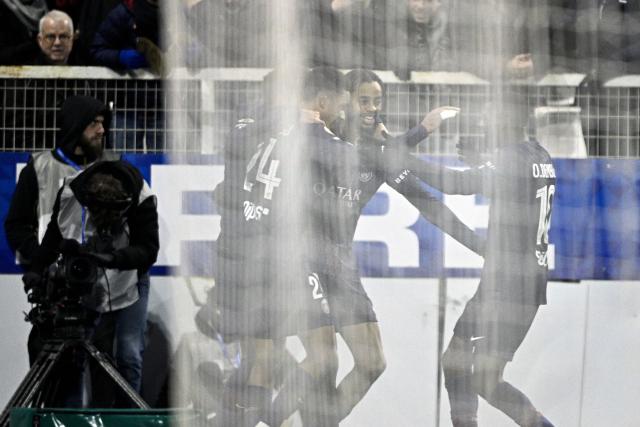 Paris Saint-Germain's French forward #29 Bradley Barcola is congratulated by teammates after scoring his team's first goal during the French L1 football match between  AJ Auxerre and Paris Saint-Germain (PSG) at Stade de l'Abbe-Deschamps in Auxerre on January 23, 2026. (Photo by JULIEN DE ROSA / AFP)