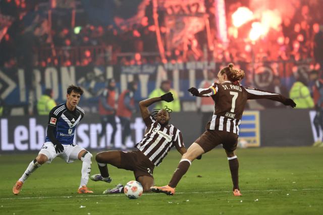 Hamburg's Croatian defender #44 Luka Vuskovic vies with St Pauli's English forward #26 Ricky-Jade Jones and St Pauli's Australian midfielder #07 Jackson Irvine during the German first division Bundesliga football derby match between FC St Pauli and Hamburg HSV in Hamburg, northern Germany on January 23, 2026. (Photo by IBRAHIM OT / AFP) / DFL REGULATIONS PROHIBIT ANY USE OF PHOTOGRAPHS AS IMAGE SEQUENCES AND/OR QUASI-VIDEO