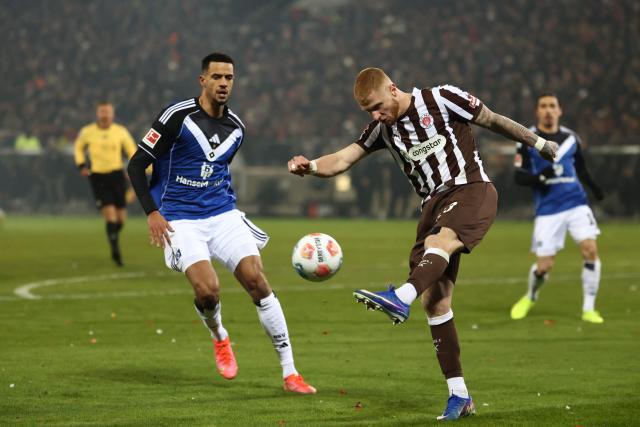 Hamburg's German forward #09 Robert Glatzel and St Pauli's German defender #23 Louis Oppie vie for the ball during the German first division Bundesliga football derby match between FC St Pauli and Hamburg HSV in Hamburg, northern Germany on January 23, 2026. (Photo by IBRAHIM OT / AFP) / DFL REGULATIONS PROHIBIT ANY USE OF PHOTOGRAPHS AS IMAGE SEQUENCES AND/OR QUASI-VIDEO