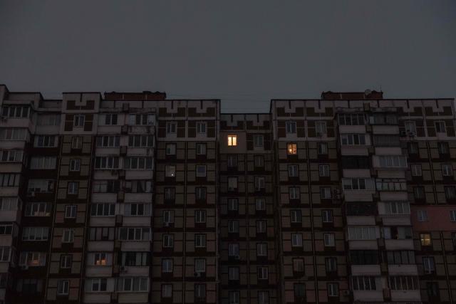 This photograph shows few windows with indoor lights on the facade of an apartment building during a power outage in a residential neighborhood of Kyiv on January 23, 2026, following Russian missile and drone attacks on Ukrainian energy infrastructure amid the Russian invasion in Ukraine. (Photo by Roman PILIPEY / AFP)