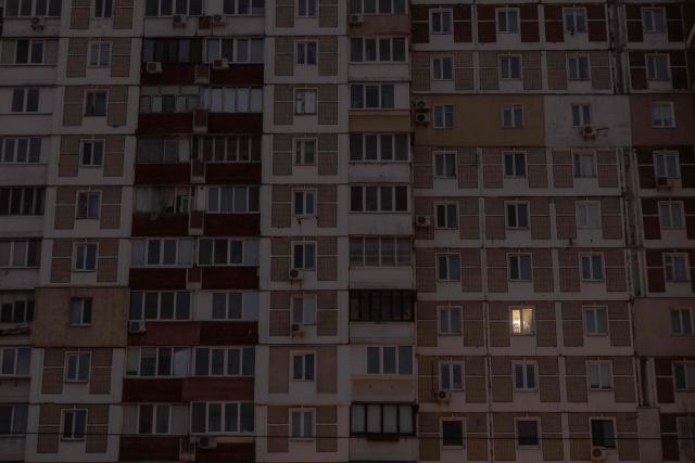 This photograph shows a window with indoor light on the facade of an apartment building during a power outage in a residential neighborhood of Kyiv on January 23, 2026, following Russian missile and drone attacks on Ukrainian energy infrastructure amid the Russian invasion in Ukraine. (Photo by Roman PILIPEY / AFP)