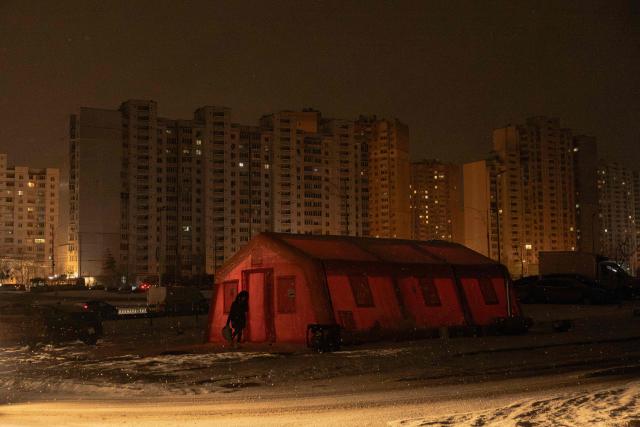 A person walks past an emergency service tent set up for those whose homes are without electricity or heating in a residential neighborhood of Kyiv on January 23, 2026, following Russian missile and drone attacks on Ukrainian energy infrastructure amid the Russian invasion in Ukraine. (Photo by Roman PILIPEY / AFP)