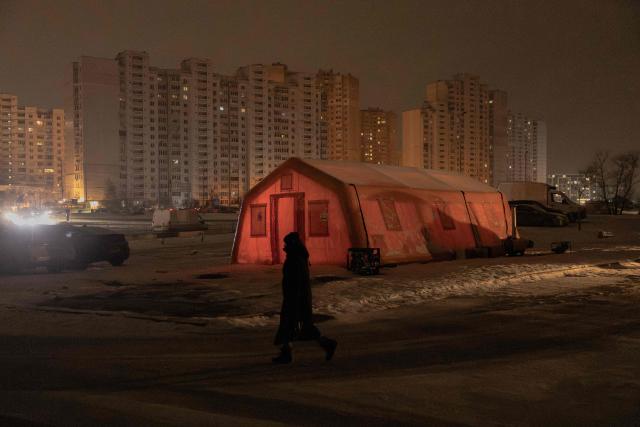 A person walks past an emergency service tent set up for those whose homes are without electricity or heating in a residential neighborhood of Kyiv on January 23, 2026, following Russian missile and drone attacks on Ukrainian energy infrastructure amid the Russian invasion in Ukraine. (Photo by Roman PILIPEY / AFP)