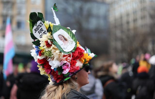 A person wears a hat made of flowers with the words "Justice for Good" as a tribute to Renee Good, who was shot and killed by a US Immigration and Customs Enforcement agent in Minneapolis, during an "ICE Out" protest in New York on January 23, 2026. Demonstrations against ICE grew dramatically following the killing of Renee Nicole Good, 37, by an ICE officer in Minneapolis on January 7 as the Trump administration pressed operations to catch undocumented migrants. (Photo by ANGELA WEISS / AFP)
