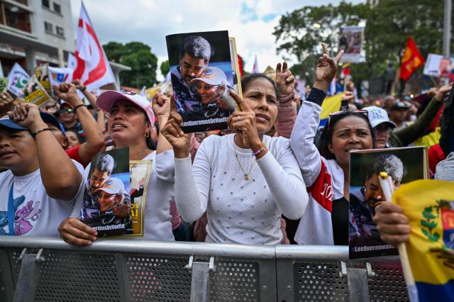 Supporters of ousted Venezuelan President Nicolas Maduro hold portraits of him as they shout slogans during a demonstration calling for the release of him and his wife from a US prison in Caracas on January 23, 2026. Thousands of Nicolas Maduro's supporters marched in Caracas on January 23, calling for the release of the ousted president, as Venezuela marked the 68th anniversary of the fall of military dictatorship. (Photo by Juan BARRETO / AFP)