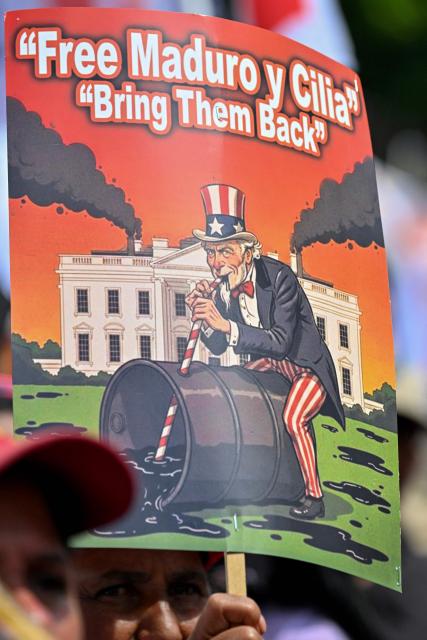 A sign depicting the US character "Uncle Sam" that reads "Free Maduro and Cilia, bring them back" is seen during a demonstration by supporters of ousted Venezuelan President Nicolas Maduro calling for the release of him and his wife from a US prison in Caracas on January 23, 2026. Thousands of Nicolas Maduro's supporters marched in Caracas on January 23, calling for the release of the ousted president, as Venezuela marked the 68th anniversary of the fall of military dictatorship. (Photo by Juan BARRETO / AFP)