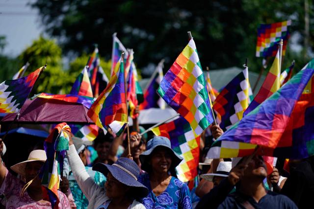 Indigenous women wave Wiphala flags during the celebrations marking the Day of the Plurinational State, in Shinaota, Bolivia, on January 23, 2026. (Photo by Pablo Rivera / AFP)